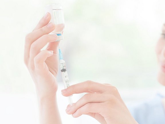Arzthelferin, die beim Facharzt für Allergien arbeitet, zieht eine Spritze auf
