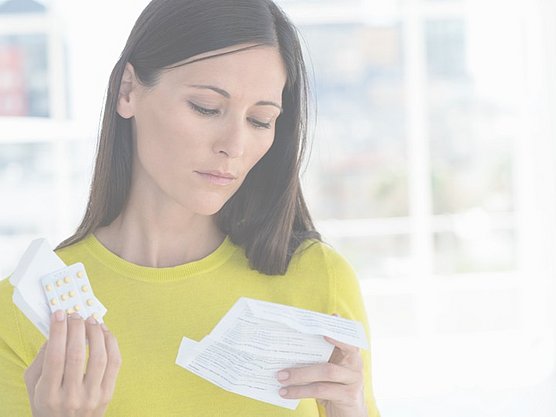 Eine Frau liesst den Beipackzettel der verschriebenen Antihistaminika.