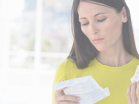 Eine Frau hält Antihistaminika in der Hand, welche ihr Allergiearzt verschrieben hat.