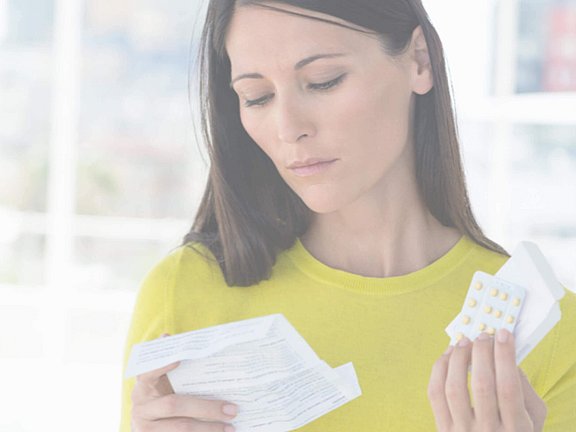 Eine Frau hält Antihistaminika in der Hand, welche ihr Allergiearzt verschrieben hat.